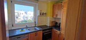 eine Küche mit einem Waschbecken und einem Fenster in der Unterkunft Wohlfühlen & Arbeiten in Toplage mit gratis Tiefgaragenplatz in Graz