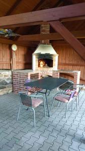 - une table de pique-nique et des chaises devant un four en briques dans l'établissement Holiday home in Jestrabi v Krkonosich 2207, à Roudnice