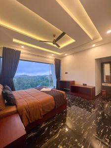 a hotel room with a bed and a large window at Dellamore Havn in Vagamon