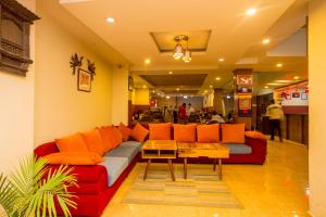 a living room with a red couch with orange pillows at Truly Asia Boutique Hotel in Kathmandu