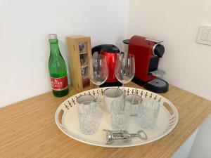 einen Teller mit Weingläsern und eine Flasche auf der Theke in der Unterkunft morand I Apartments in Salzburg