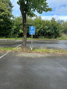 una señal azul de estacionamiento al lado de una carretera en Moderne und komfortable Appartements im Ferienpark Hahnenklee en Hahnenklee-Bockswiese