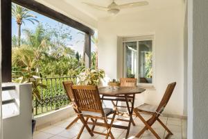 a dining room with a table and chairs on a balcony at Charming and spacious apartment in Medina Garden - Puerto Banús in Marbella