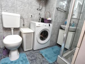 a bathroom with a toilet and a washing machine at Apartman Vrancic in Banja Luka