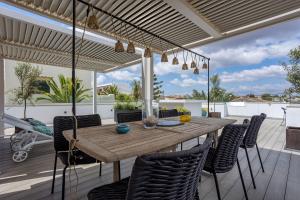 an outdoor dining room with a wooden table and chairs at La casa Escaniana in Cala Santanyi