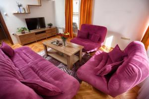 a living room with two purple couches and a table at Apartman Vrancic in Banja Luka