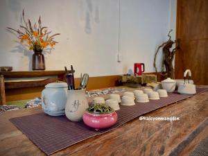 a group of white vases on a wooden table at Một Homestay Mang Den in Kon Von Kla