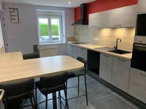 a kitchen with a counter and a sink and a table at RELAIS ERMESINDE in Marville