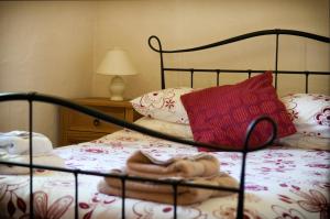 a bed with a red pillow and a doll on it at RB Contractor Stays - Dderwen in Pwllheli