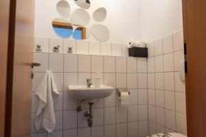 a white bathroom with a sink and a toilet at Klassen Apartments! Zentral und bequem, entdecken Sie Bad Schussenried in Bad Schussenried