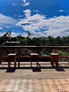 a pair of benches sitting on a wooden deck at Halcyon Homestay Mang Den in Kon Von Kla