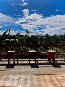 a pair of benches sitting on a wooden deck at Một Homestay Mang Den in Kon Von Kla +15 photos
