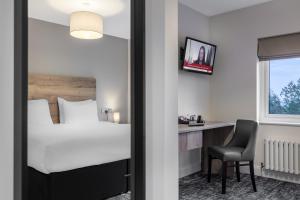 a hotel room with a bed and a desk at The Stones Hotel in Salisbury