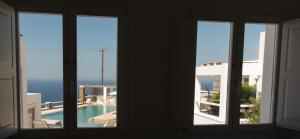 a room with three windows with a view of a pool at Lemon Tree Houses in Áno Meriá