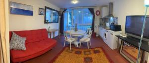 een woonkamer met een rode bank en een tafel bij Apartamento abierto con patio in Matadepera