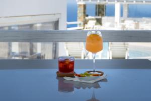 a drink and a bowl of fruit on a table at Lemon Tree Houses in Áno Meriá