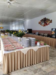 a long table with plates of food on it at Ośrodek Wypoczynkowy Ania Dźwirzyno in Dźwirzyno