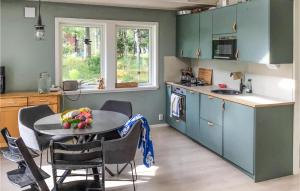 una cocina con armarios azules y una mesa con fruta. en Stunning Home In Edsbro With Wifi, en Edsbro