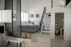 a bedroom with a bed and a staircase in a room at Lemon Tree Houses in Áno Meriá