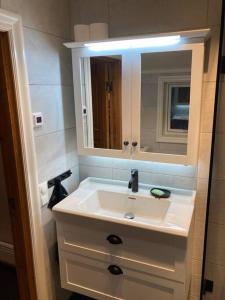 bagno con lavandino bianco e specchio di Fantastiskt 10+2bädds stuga i Klövsjö a Klövsjö