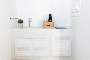 a white kitchen with a sink and white cabinets at Lemon Tree Houses in Áno Meriá
