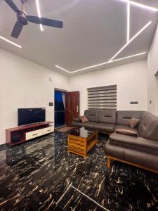 a living room with a couch and a flat screen tv at ADAM'S FORT by Dell'amore Havn in Vagamon