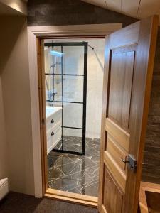 ein Badezimmer mit einem Spiegel, einem Waschbecken und einer Tür in der Unterkunft Fantastiskt 10+2bädds stuga i Klövsjö in Klövsjö