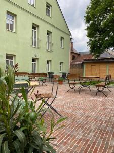 a group of benches and tables in front of a building at Apartmany Tachov Garden House in Tachov
