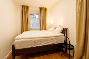 a bed in a small room with a window at Apartmany Tachov Garden House in Tachov