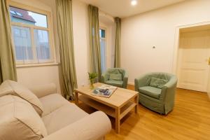 ein Wohnzimmer mit einem Sofa, 2 Stühlen und einem Tisch in der Unterkunft Apartmany Tachov Garden House in Tachov
