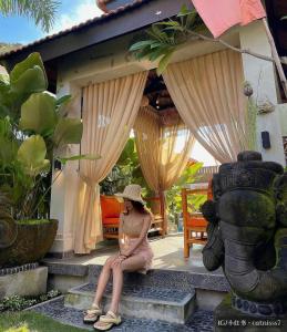 a woman sitting on the steps of a house at The Kembali Luxury Villa - Melaka 5 Bedroom in Malacca