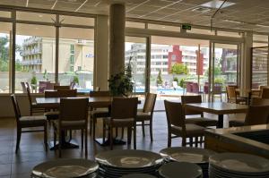 un ristorante con tavoli e sedie e vista sulla piscina di Hotel Belle View a Kranevo