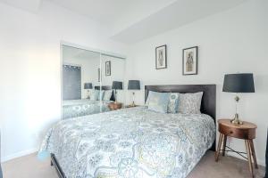 a bedroom with a large bed and a mirror at Globalstay. Burano Condos in Downtown Toronto in Toronto