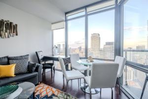 a living room with a table and chairs and a large window at Globalstay. Burano Condos in Downtown Toronto in Toronto