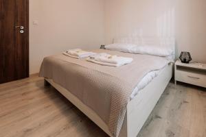 a bedroom with a bed with two towels on it at SKAU 1 Old Town Family & Business Apartment 1floor Free parking in Bratislava