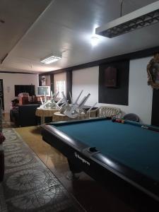 a living room with a pool table and chairs at GG Resort in Dalumpinas Oeste