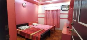 mały czerwony pokój z małym łóżkiem w obiekcie GG Resort w mieście Dalumpinas Oeste