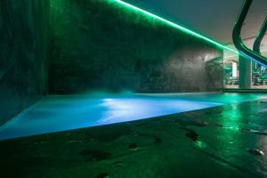 リヴィーニョにあるFiori Bluの青と緑のライトがついた空のプール