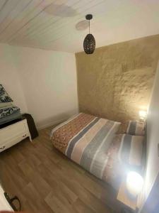 Un dormitorio pequeño con una cama en una habitación. en Petite maison plain-pied climatisé, en Migné-Auxances