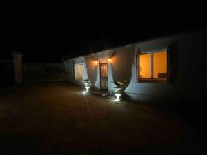 Una casa de noche con luces en la oscuridad en Petite maison plain-pied climatisé, en Migné-Auxances