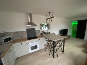 a kitchen with a table and a counter top at Petite maison plain-pied climatisé in Migné-Auxances
