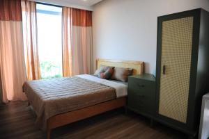 a bedroom with a bed with a large window at Tú Viên Homestay Ecopark/ 165m with big garden in HÆ°ng YÃªn