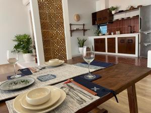 a dining table with plates and wine glasses on it at Tú Viên Homestay Ecopark/ 165m with big garden in HÆ°ng YÃªn