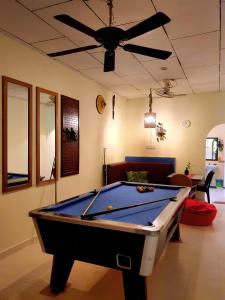 a pool table in a living room with a ceiling fan at THE COTTAGE LANGKAWI in Pantai Cenang