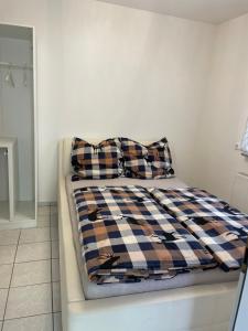 uma cama com um cobertor xadrez e duas almofadas em Vida Real Estate Feucht em Feucht