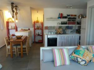 a living room with a couch and a table and a kitchen at Spitaki-Kythnos in Loutra
