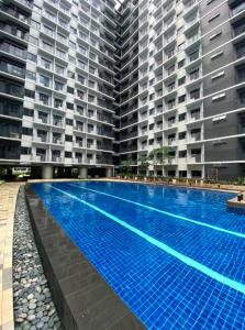 a large swimming pool in front of two large buildings at Pasay Condotel with Massage Chair and PS4- Stellar Suites in Manila