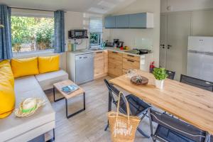 kuchnia i salon z kanapą i stołem w obiekcie Camping la Corniche w mieście Plozévet