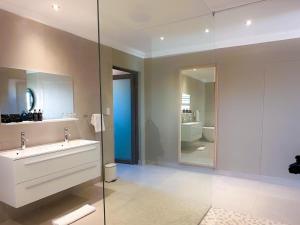 a bathroom with a sink and a glass wall at Bagatelle Kalahari Boutique Farmhouse Lodge in Mariental