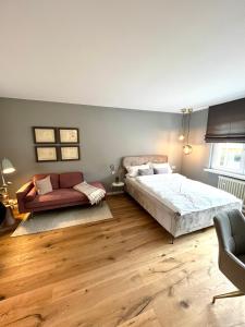 um quarto com uma cama e um sofá em Premium Apartment an der Stadtmauer im OG em Paderborn